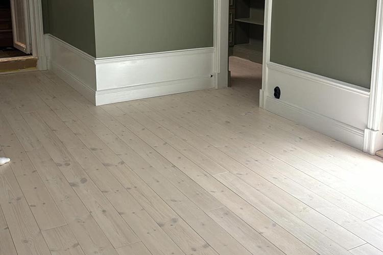 Renoverat trägolv i ljus träton med stilren och modern finish